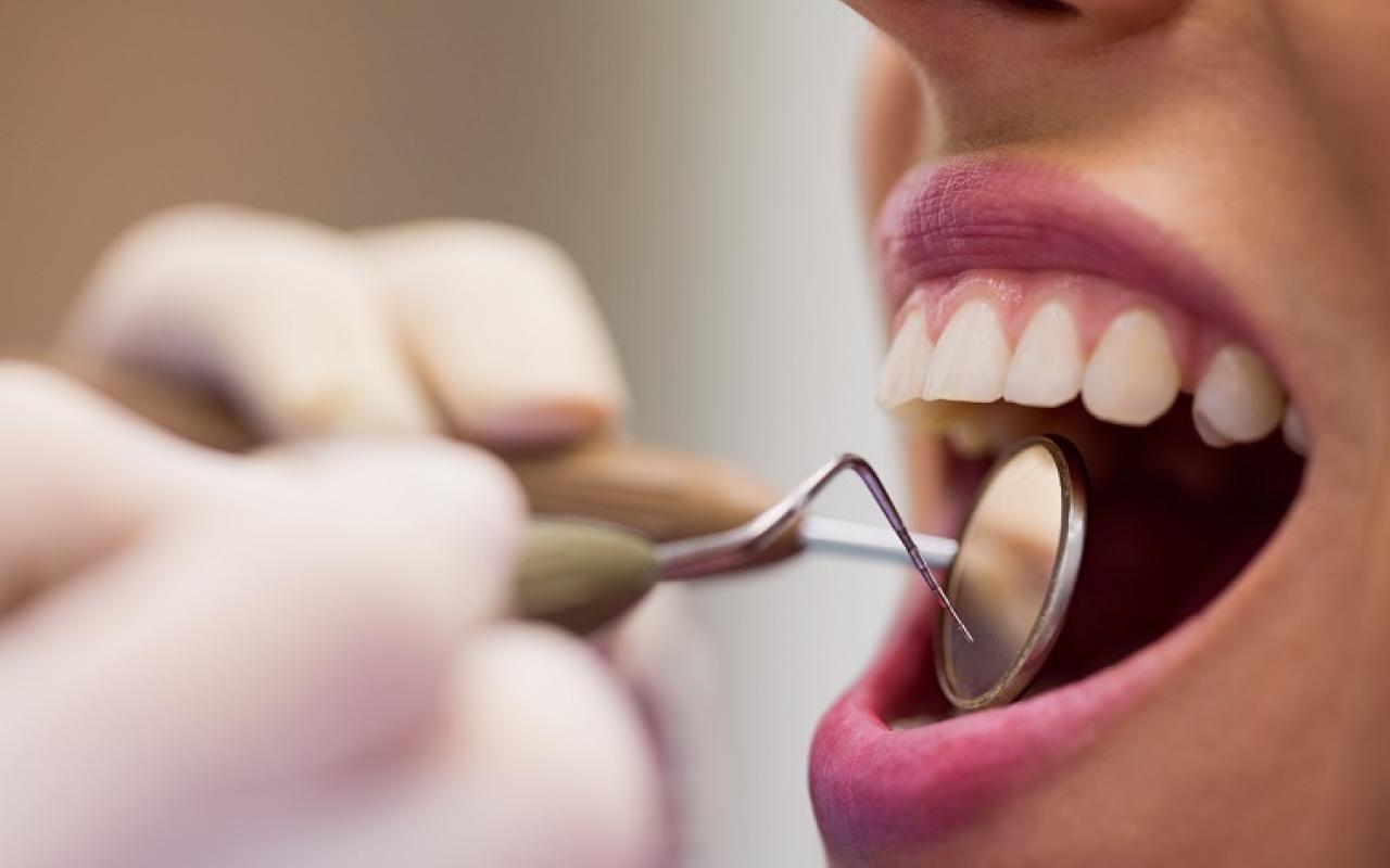 dentist-examining-a-female-patient-with-tools