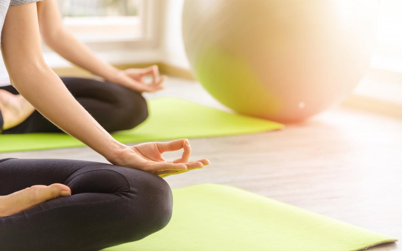 Two youngs attractive women sitting practicing yoga