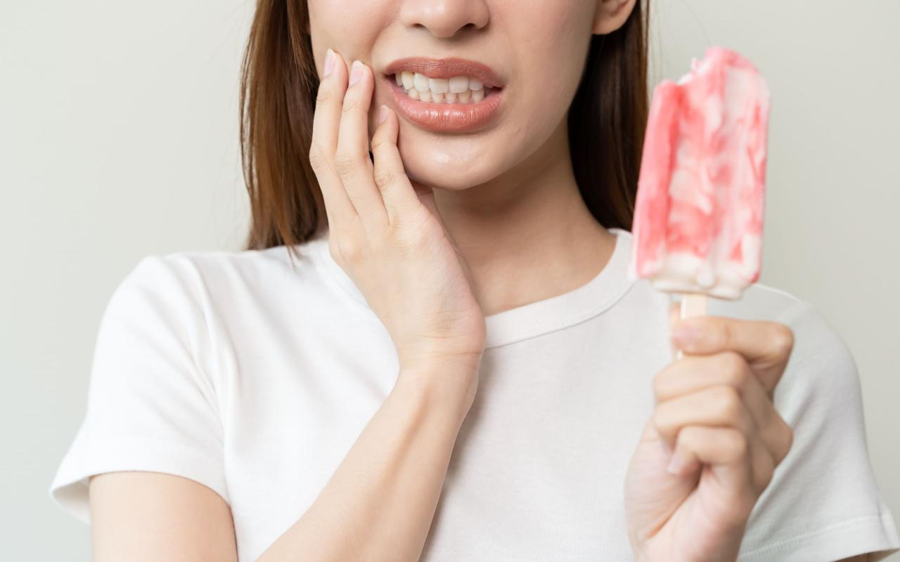 donna con gelato che prova dolore al dente