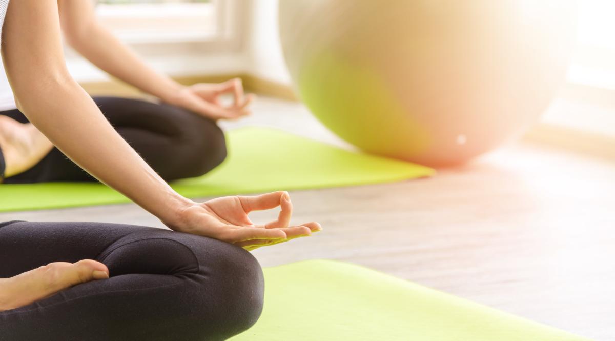Two youngs attractive women sitting practicing yoga