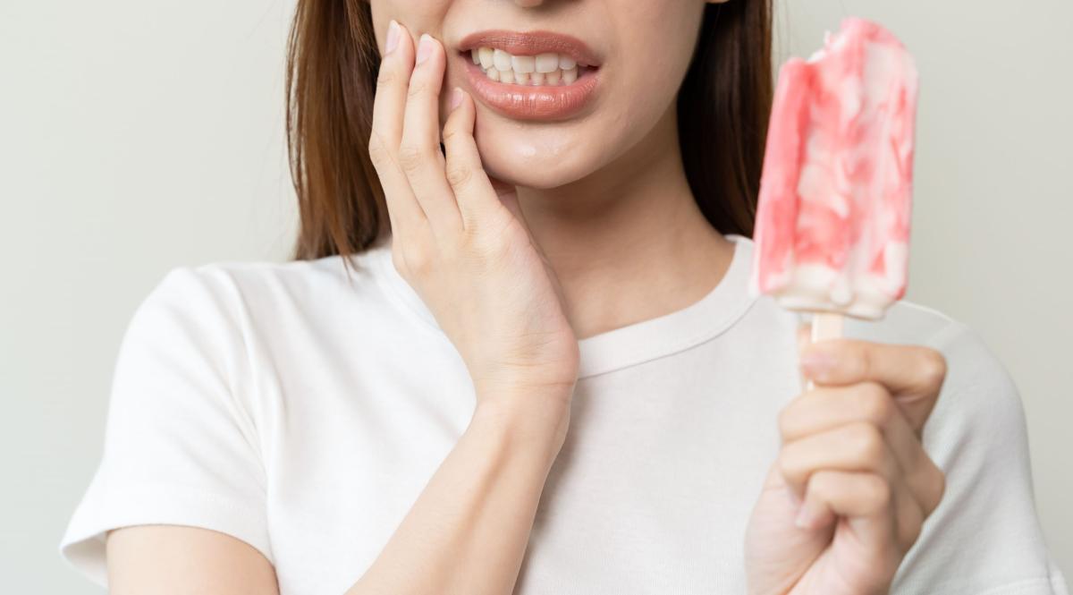 donna con gelato che prova dolore al dente