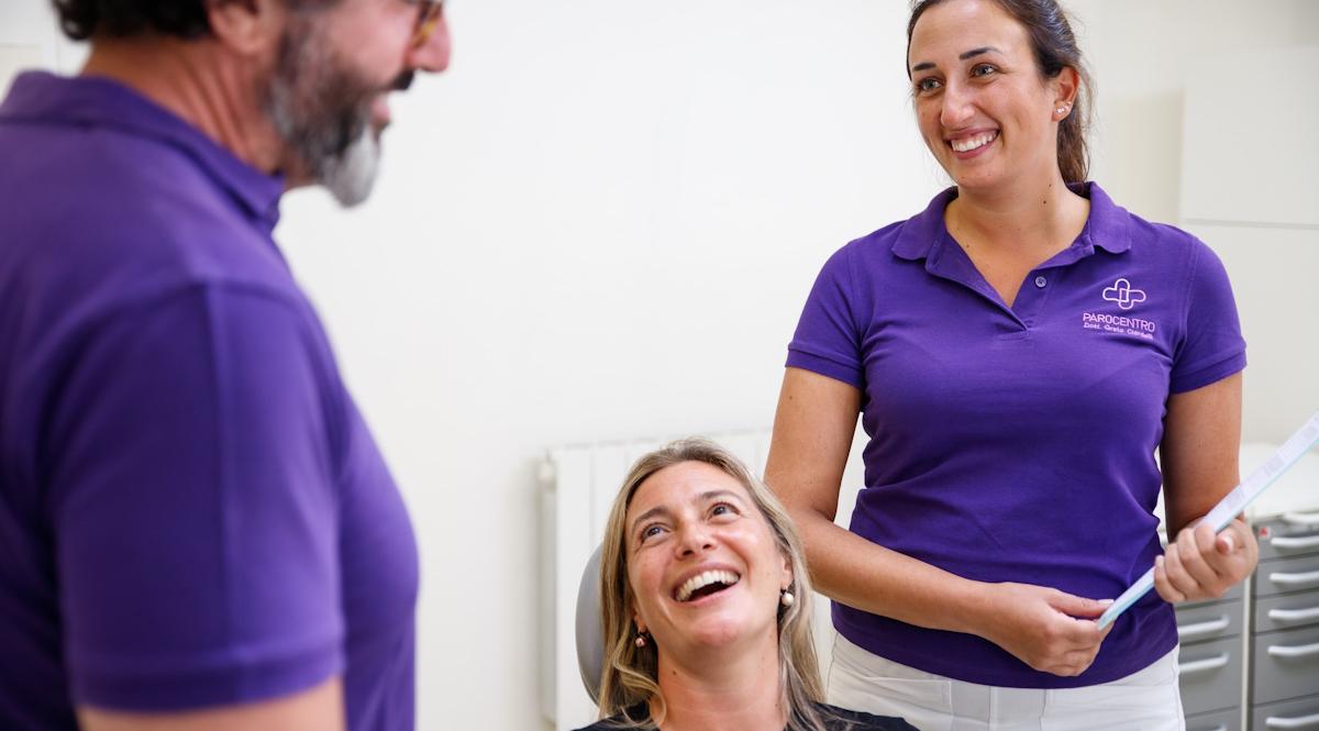 dentista con assistente e paziente ridono felici